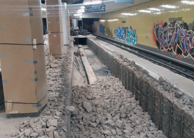 Baustelle der U-Bahn-Station Borsigwerke mit aufgerissenem Gleisbett, Trümmern auf dem Boden, mehreren Säulen und Graffiti an den Wänden